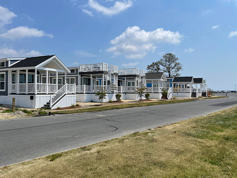 homes--rv-sites A row of manufactured homes on a tree-lined street in the community