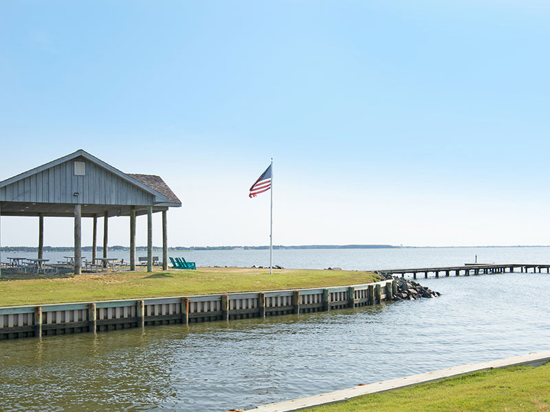 waterfront-pavilion Covered picnic pavilion with tables, set on the water's edge
